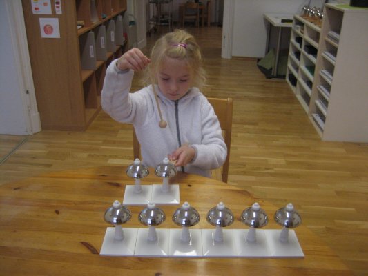 Arbeit mit Montessori-Glocken - Ziele: Wahrnehmung unterschiedlicher Tonhöhen, Entwicklung des musikalischen Gehörs und des musikalischen Gedächtnisses, Entwicklung der Stimme für das Singen, Vorbereitung auf die musikalische Erziehung, Vorbereitung auf das Schreiben und Lesen